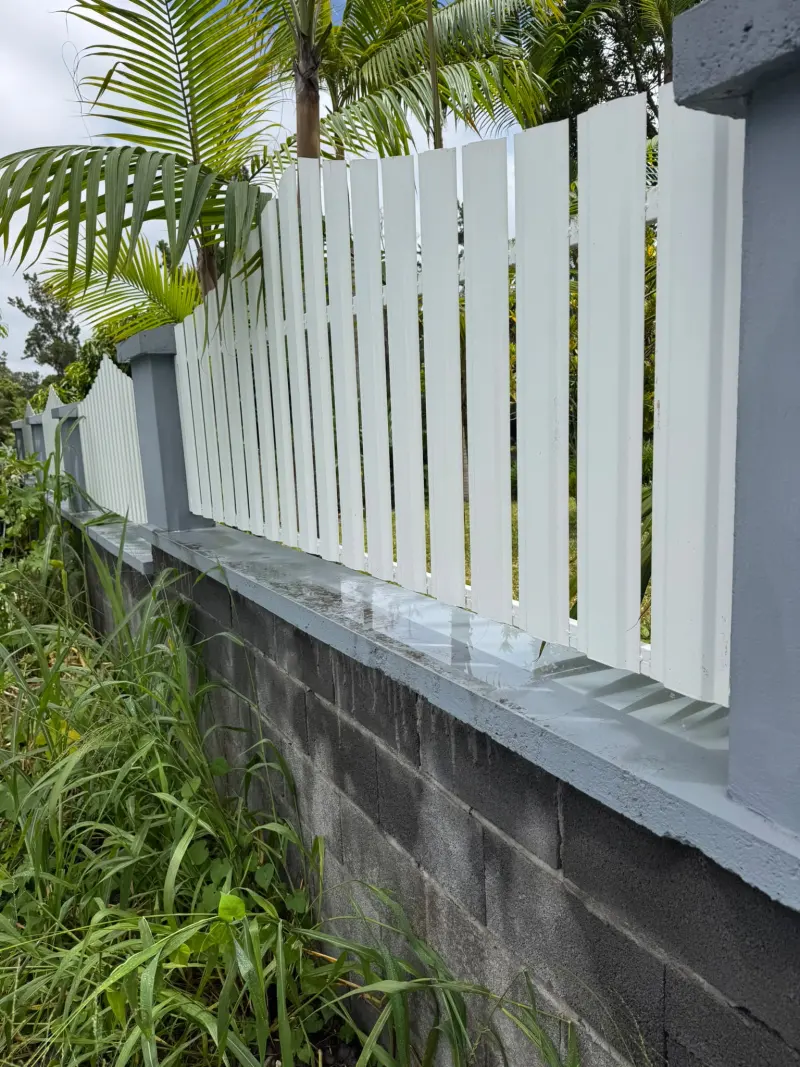 Après : clôture repeinte en blanc avec muret gris